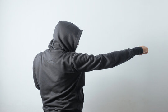 side view of hooded man with punch gesture