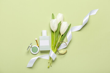 Cosmetic products with bracelet and tulips on green background. Mother's Day celebration