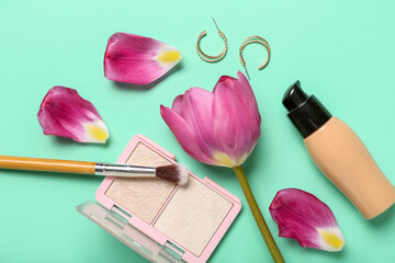 Obraz na płótnie Canvas Cosmetic products with earrings and tulip on blue background. Mother's Day celebration