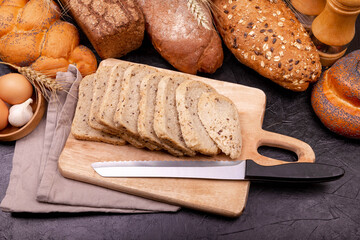 Different types of bread. Top view. Concept of homemade bread, natural farm products, domestic production. Healthy and tasty organic food. Assortment of baked bread on grey background.