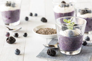 Fototapeta na wymiar Blueberry chia puddings topped with vanilla yogurt and berries.