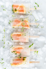 Light and refreshing grapefruit and thyme popsicles on a bed of ice.