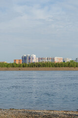 Naklejka premium view of the city from the river bank on a summer day
