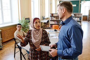 Young Muslim woman wearing hijab telling poem by heart during English lesson for group of immigrants