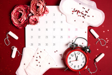 Menstrual calendar for menstruation control with hygiene products, flowers and an alarm clock.