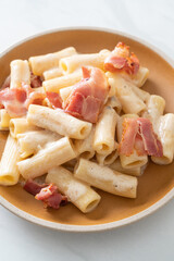 spaghetti rigatoni pasta with white sauce and bacon