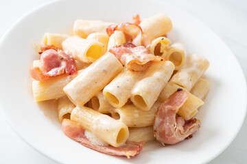 spaghetti rigatoni pasta with white sauce and bacon