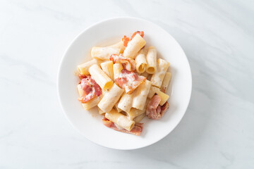 spaghetti rigatoni pasta with white sauce and bacon