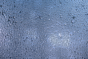 Wet glass texture, sweaty window. Abstract blue background.