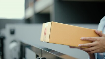 Close up parcel in hand of blue uniform delivery man to customer front of the house with good service from shopping online. Courier man delivering a cardboard box postal package to destination.