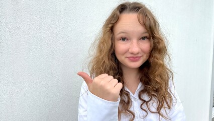 a girl on a white background in a white blouse, fair-haired, shows different cheerful emotions, she makes faces, she laughs happily, she ruffles her hair and shows her tongue. High quality photo