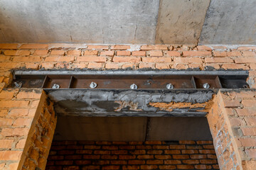 Reinforcement of interior openings with iron channels. Doorway in a load-bearing wall. red brick wall