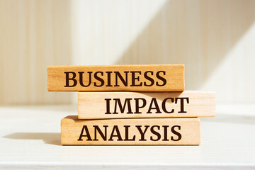 Wooden blocks with words 'BUSINESS IMPACT ANALYSIS'. Business concept.