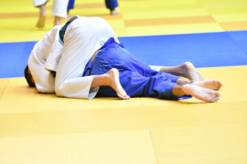 Two Boys judoka in kimono compete on the tatami 