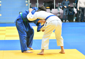 Two Boys judoka in kimono compete on the tatami 