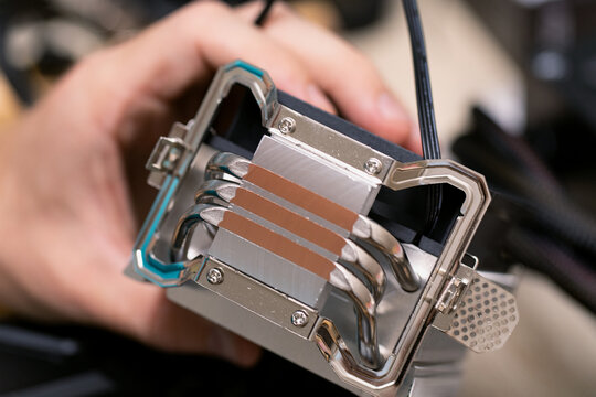 PC CPU air cooling system. Aluminum heat sink in hand of technicians man. Selective focus