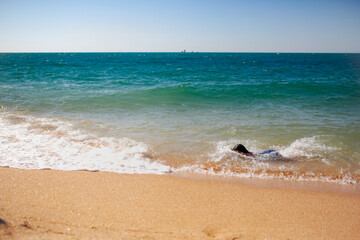 girl or child in a swimsuit swims underwater along the edge of the sea near the shore, summer vacation and children's safety