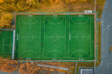 Aerial view of amateur mini football playground with practicing and training sportsmans