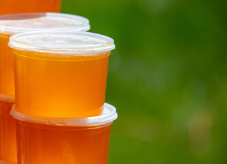 Honey in plastic jars in nature.
