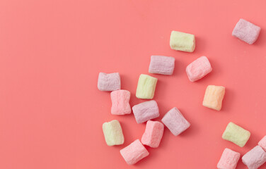 Multicolored candies on a pink background. Close-up