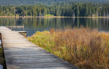 Idyllic view of a wooden pier in the lake with mountain scenery background in cloudy morning