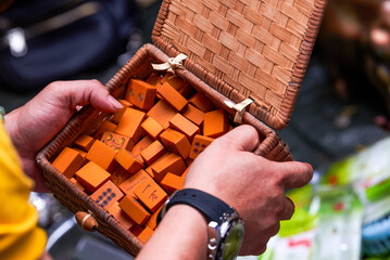 A man in the market holds a box of traditional Chinese mahjong made of bamboo