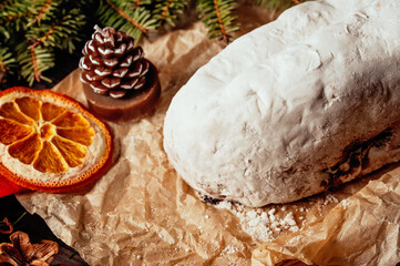 Christmas stollen on wooden background. Traditional christmas german dessert cut into pieces. Cake with nuts, raisins with marzipan and dried fruit on cutting board. baking for xmas