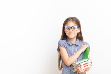 A 7-year-old girl in glasses with books with a surprised face. Children's education, learning concept with copy space