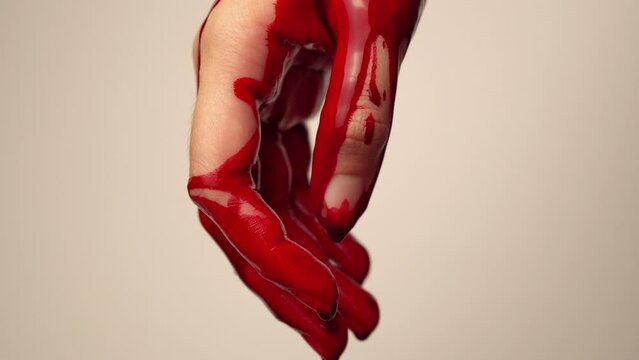 macro shot of a murderer showing a bloody hand.