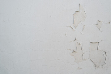 Gray paint cracked plaster on concrete wall, outdoors. Textured rough background with copy space