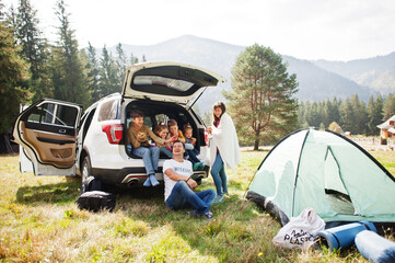 Large family of four kids. Children in trunk. Traveling by car in the mountains, atmosphere...