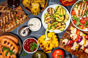 Grilled summer bbq dishes. Bar-b-q party picnic flatlay with various barbecue grill food - shish kebab skewers, grilled corn, salad with bonfire fried chicken, steak, sausages, vegetables top view