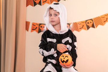 Close-up portrait of a boy in a skeleton costume. Halloween party background