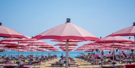 the red umbrellas blend with the colors of the sky and the sea