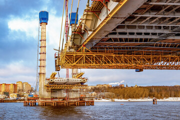 Construction of a new road bridge continues across the Sheksna river. Cable-stayed bridge in...