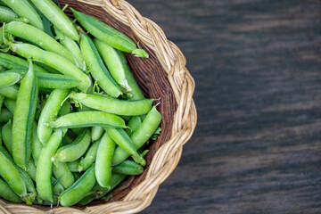 fresh peas in pods in a basket with copy space. Healthy eating concept