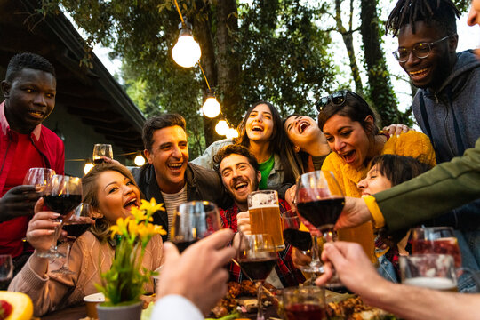 Multiracial Young people having funon terrace garden – group multiethnic friends drinking beer and wine