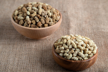 Bowl full of dried mulberry on a fabric background