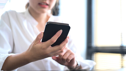 Cropped shot young asian woman and using smart phone for communicating in social network