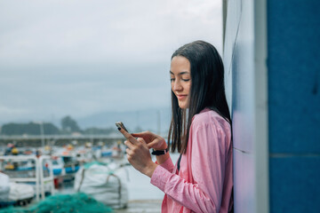 asian young tourist woman in marina with phone
