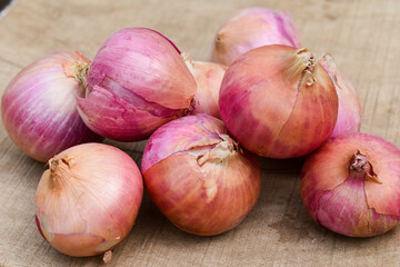 Fresh red onions on rustic wood background