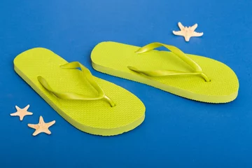Schilderijen op glas Beach accessories. Flip flops and starfish on colored background. Top view Mock up with copy space © sosiukin