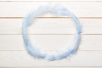 Frame of brightly colored dyed bird feathers on Colored background, top view