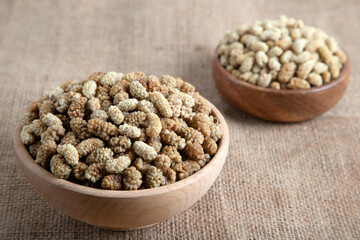 Bowl full of dried mulberry on a fabric background