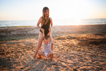 Fototapeta premium Sister girls in swimsuits run and play on the seashore, free summer vacation and happy children