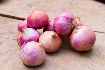 Fresh red onions on rustic wood background