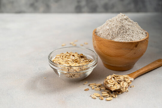 Oat wholegrain flour in wooden bowl. Gluten - free flour concept. Copy space