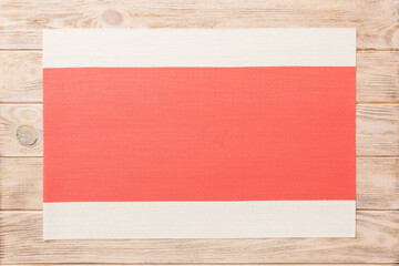 Top view of red tablecloth for food on wooden background. Empty space for your design