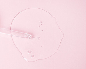 Cosmetic transparent oil, serum or gel and pipette on a pink background. Medicine, beauty and health concept