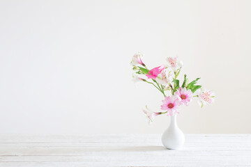 pink and white flowers in vase on white background